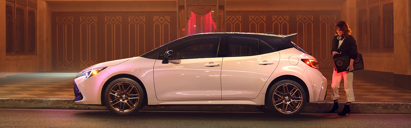 side view of a white 2025 Toyota Corolla Hatchback parked on a street