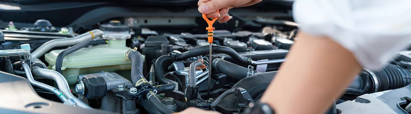mechanic pulling the dipstick out to check the oil