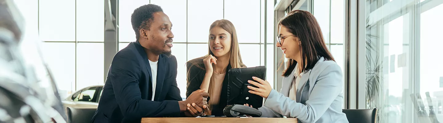 man and woman looking over a tablet with a saleswoman