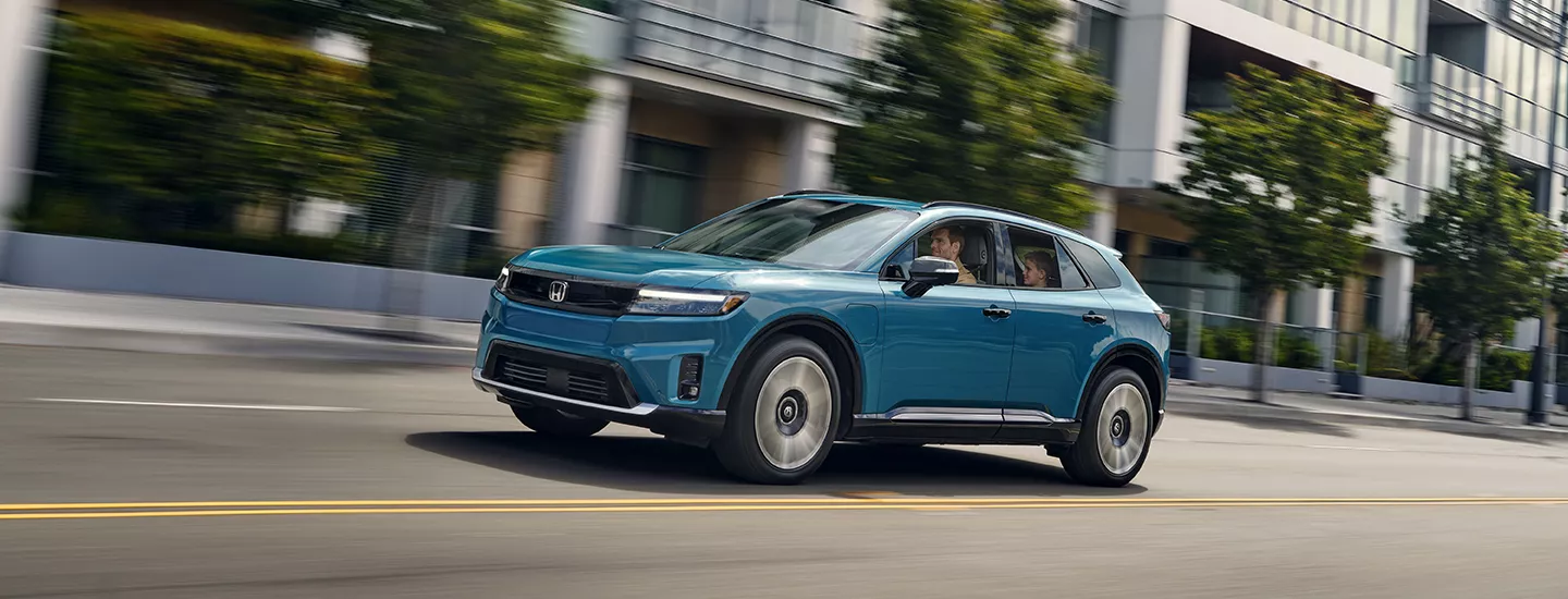 2026 Honda Prologue driving through the city with a family inside
