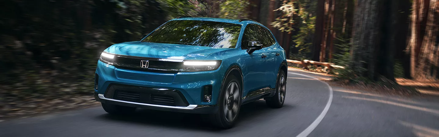 2026 Honda Prologue driving on a wooded road