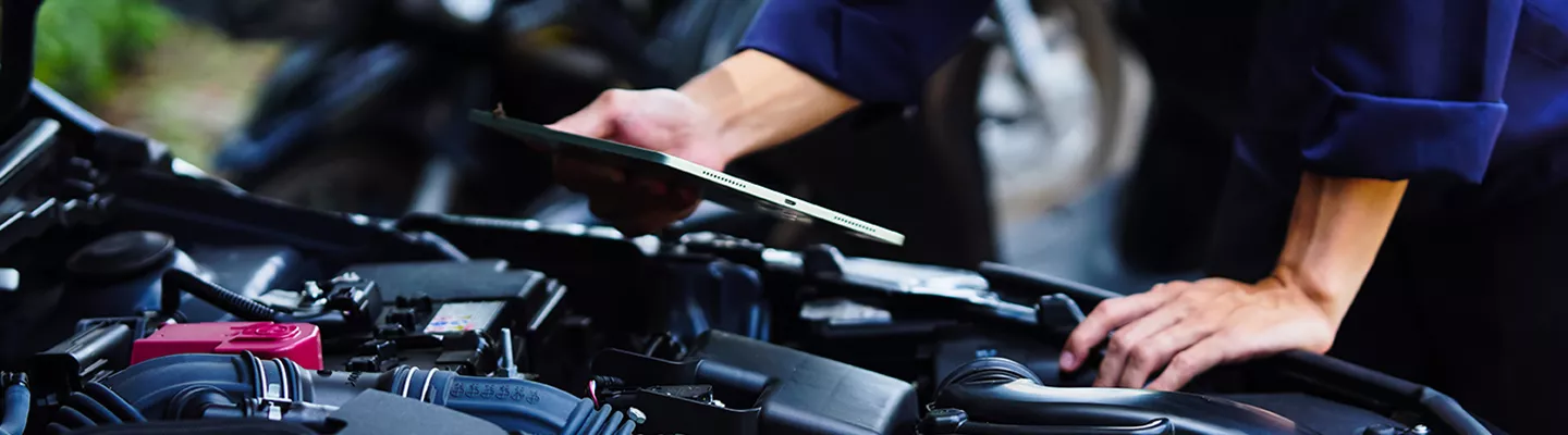 mechanic holding tablet diagnosis vehicle