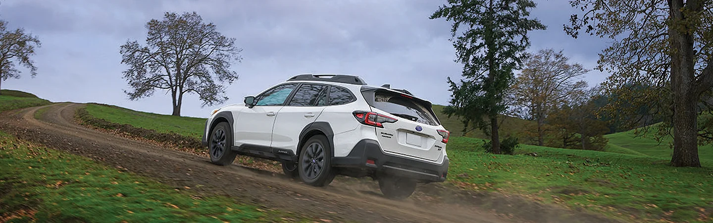 2025 Subaru Outback driving up a dirt road around a curve in Waco, TX