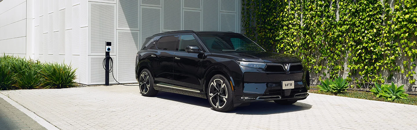 black 2025 VinFast VF 9 Eco by charging station