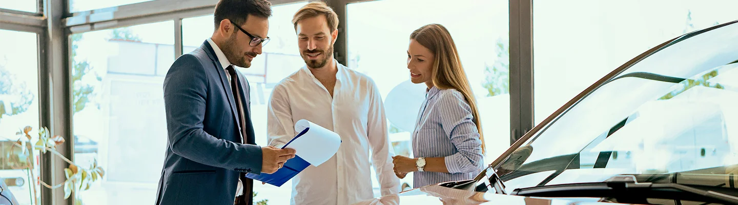 Sales person talking to customers about Trading in there Vehicle