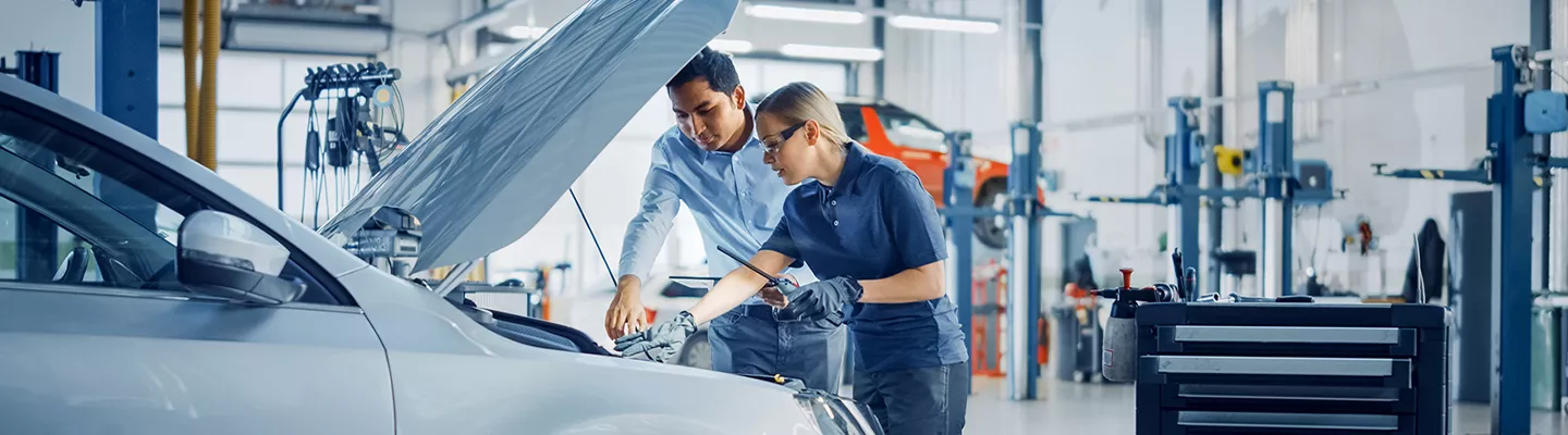 Service technician looking at a car's oil level