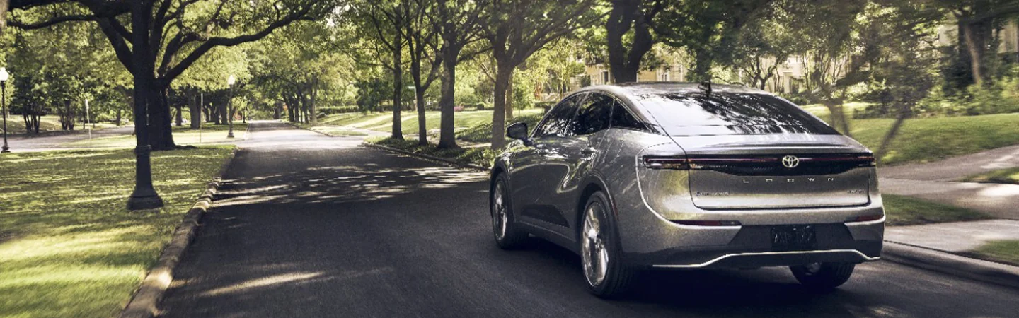 back view of a 2025 Toyota Crown driving though houses