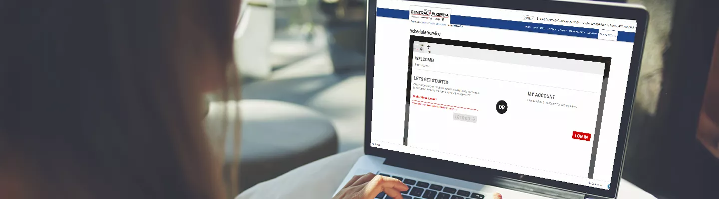 woman typing on laptop scheduling service at Central Florida CDJR
