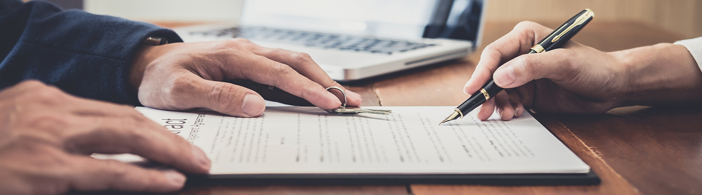 Image of someone signing a document