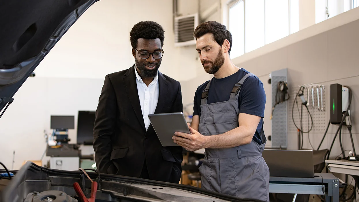 auto mechanic speaking with customer in service bay
