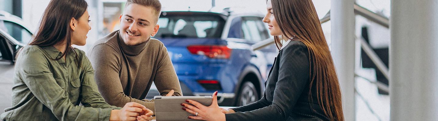 Sales professional working with a client on a used car deal