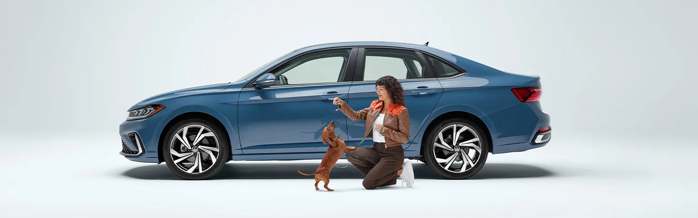 side view of 2025 Volkswagen Jetta SEL with a person feeding a dog beside it