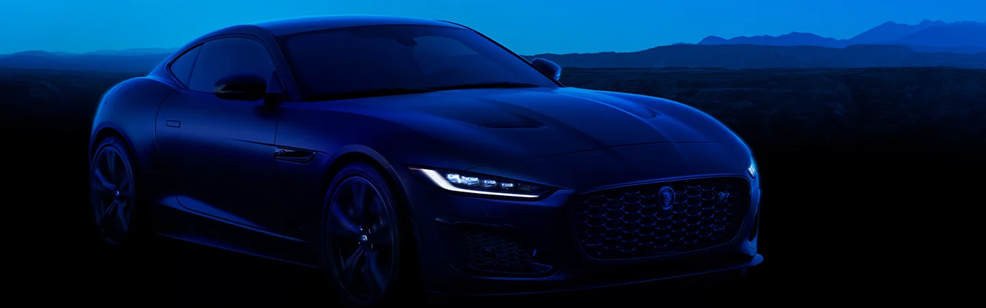 headlights on on the 2024 Jaguar F TYPE P450 R Dynamic parked with mountain in background