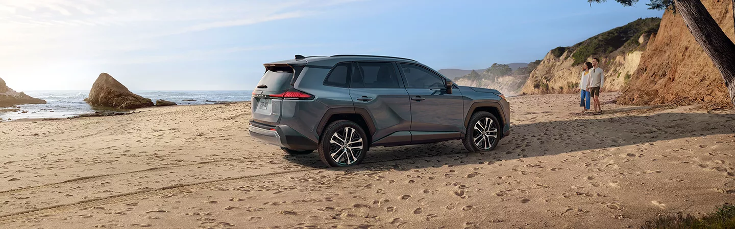 2026 Toyota RAV4 parked on the beach with people in the background
