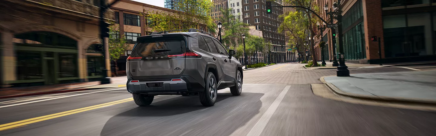 Rear view of the 2026 Toyota RAV4 driving through the city