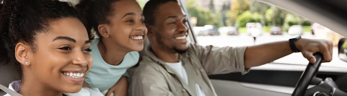 a family smiling as they test drive their new VW