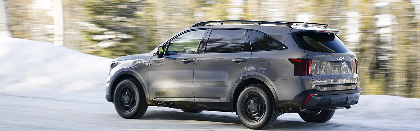 A 2025 Kia Sorento next to snow covered woods