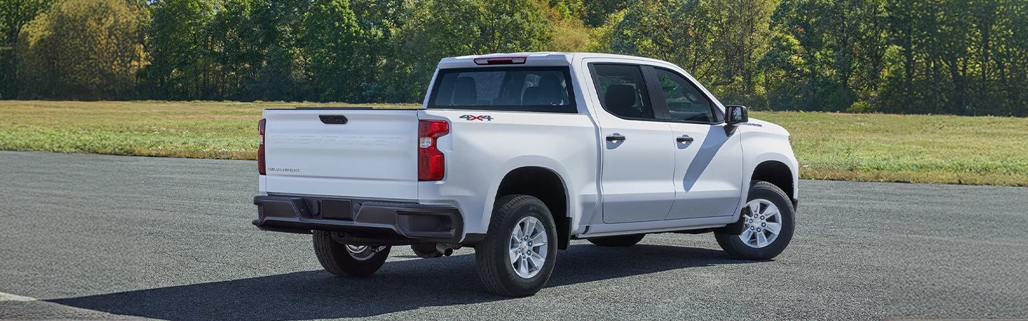 Back view of a 2025 Chevrolet Silverado 1500 parked by the woods