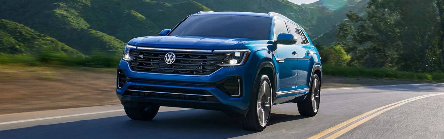 fromt view of a blue 2025 Volkswagen Atlas Cross Sport in motion