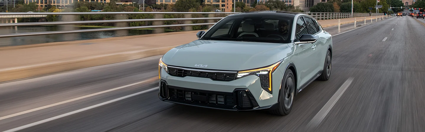 2025 Kia K4 Sliver color car on road Front view