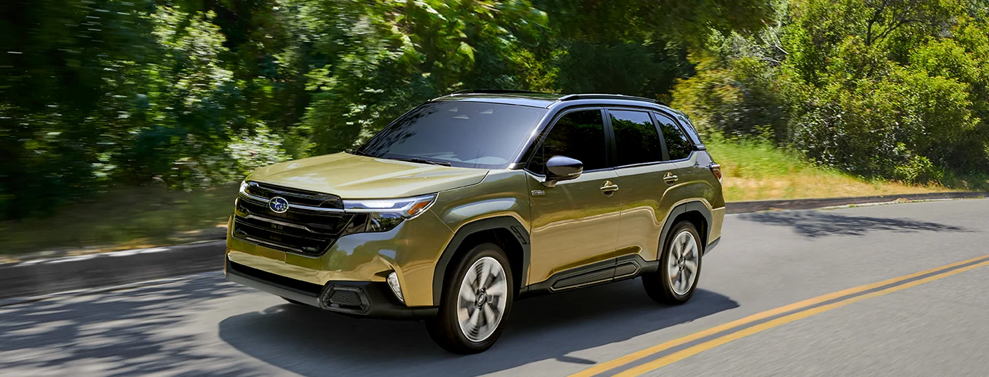 2025 Subaru Forester Hybrid driving down a winding road