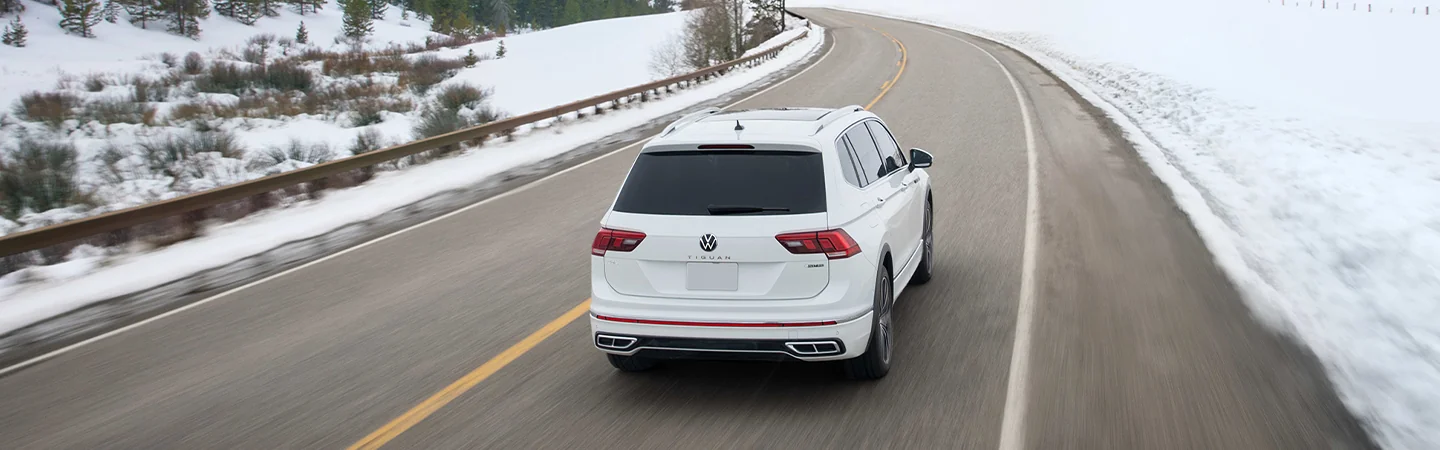 Man getting into a 2025 Volkswagen Tiguan on a city street