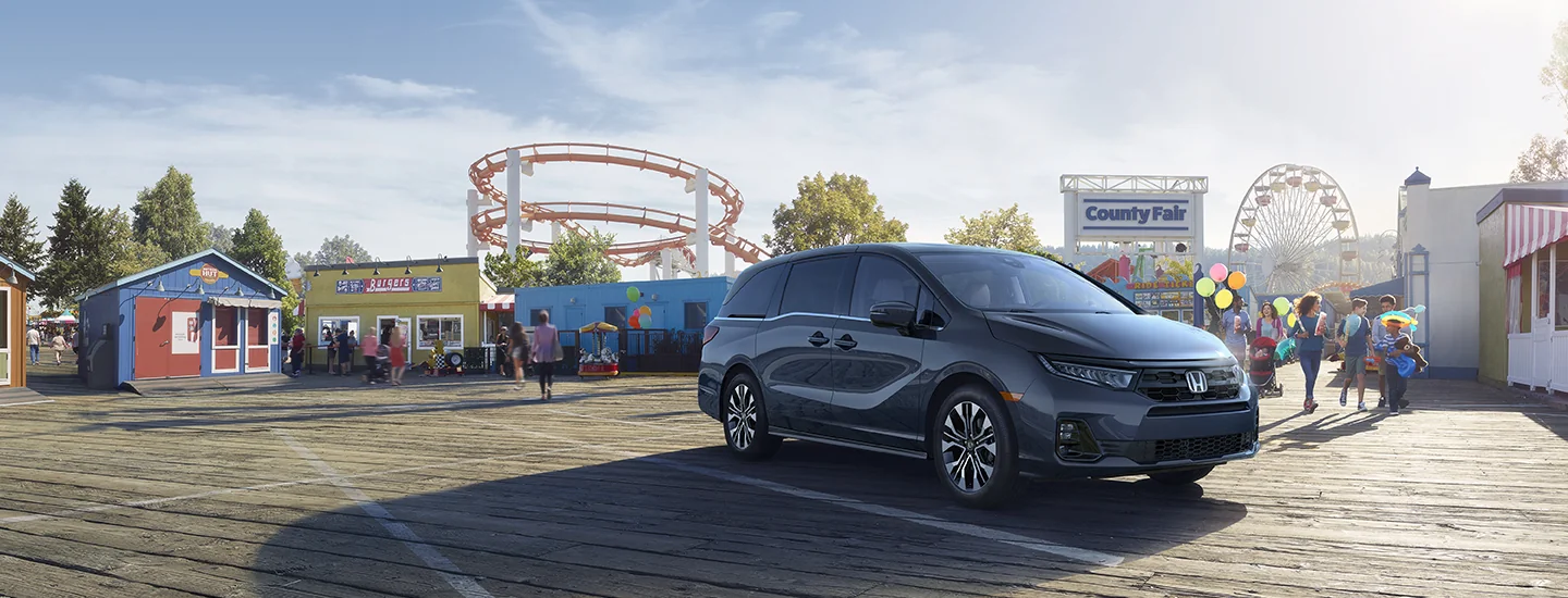 front view of a 2026 Honda Odyssey on boardwalk by amusement park