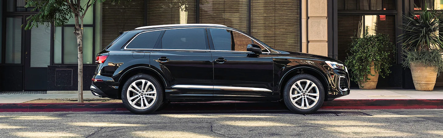 Side view of a black 2025 Audi Q7 parked on a city street