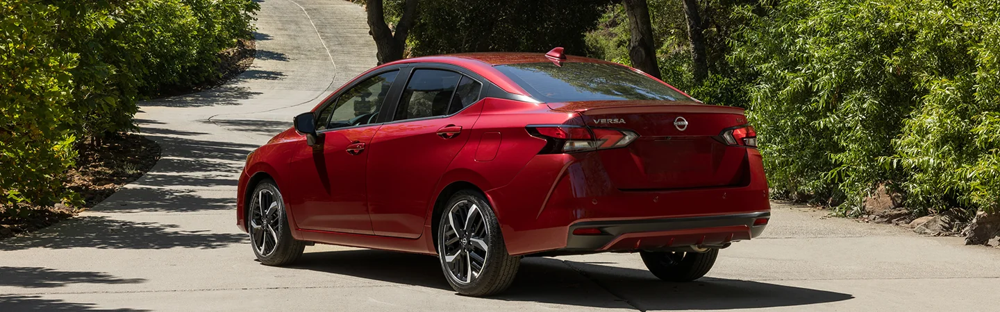 red 2025 Nissan Versa parked on hill road back view