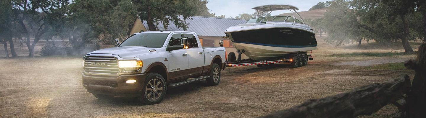 A white 2021 RAM 2500 towing a boat