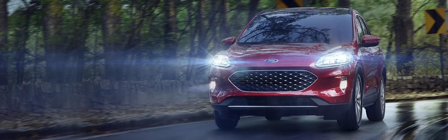 A red 2021 Ford Escape driving on a wet road
