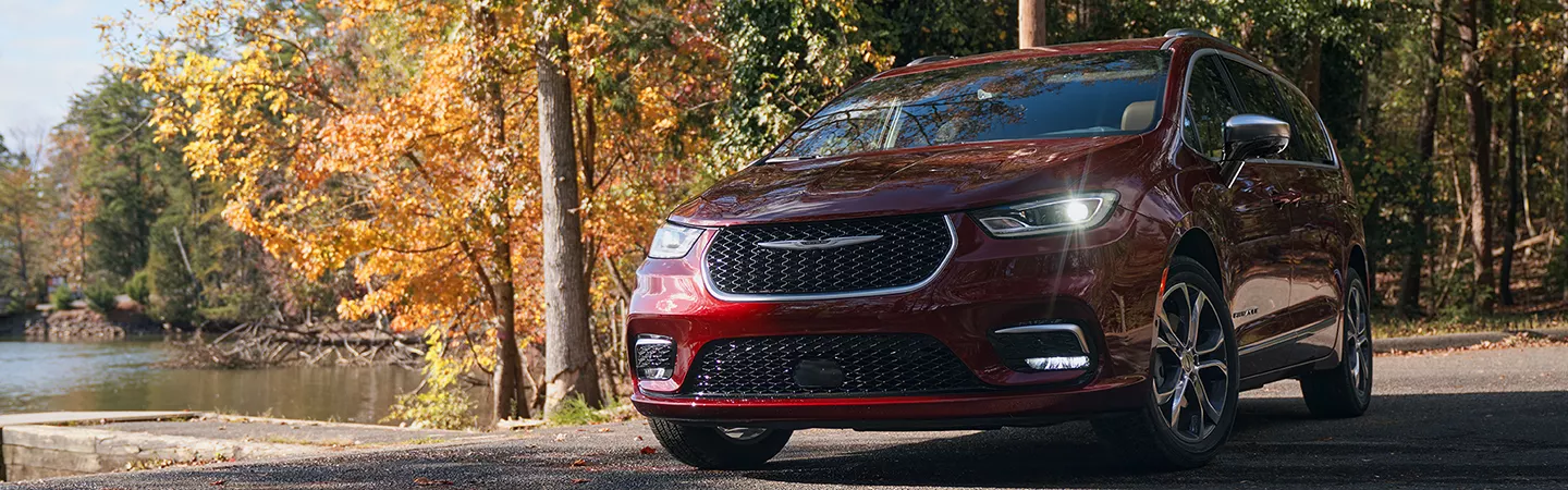 Close up of the 2026 Chrysler Pacifica parked in a wooded lot in autumn