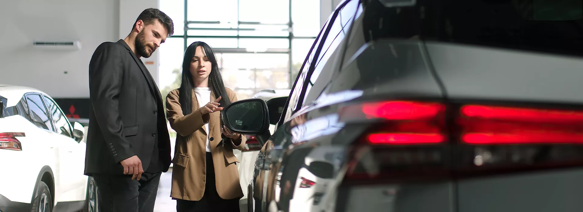 Two people looking at a Subaru vehicle in a car dealership