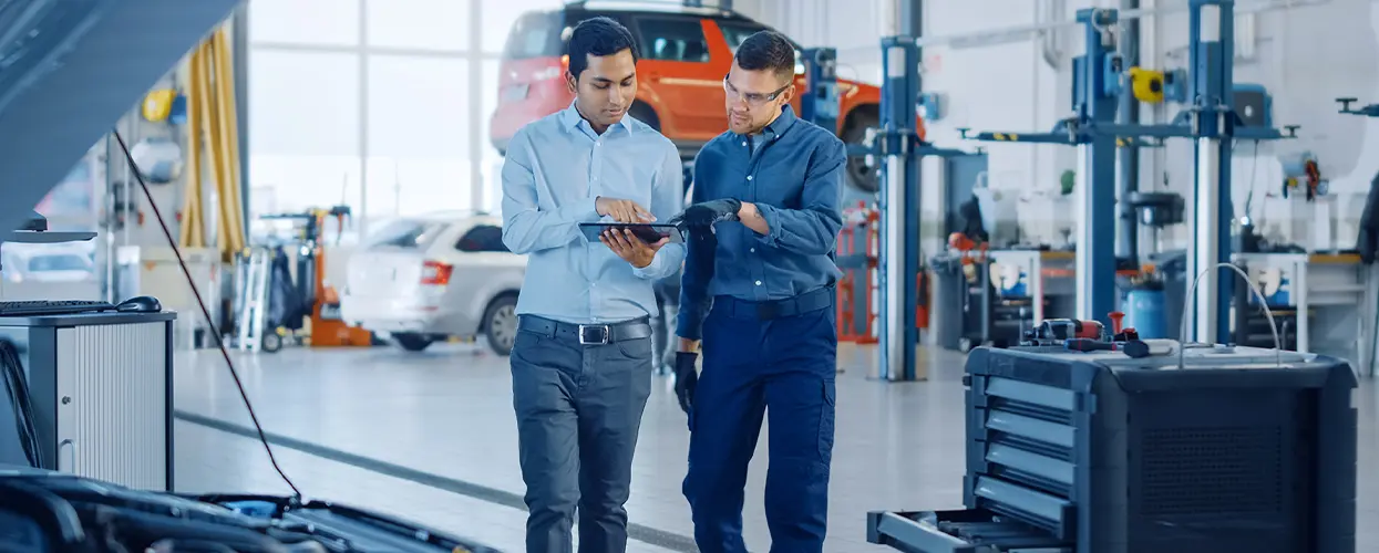 techs in repair bay discussing terms