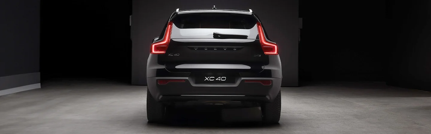 Rear view of a 2026 Volvo XC40 parked in a darkly lit parking garage