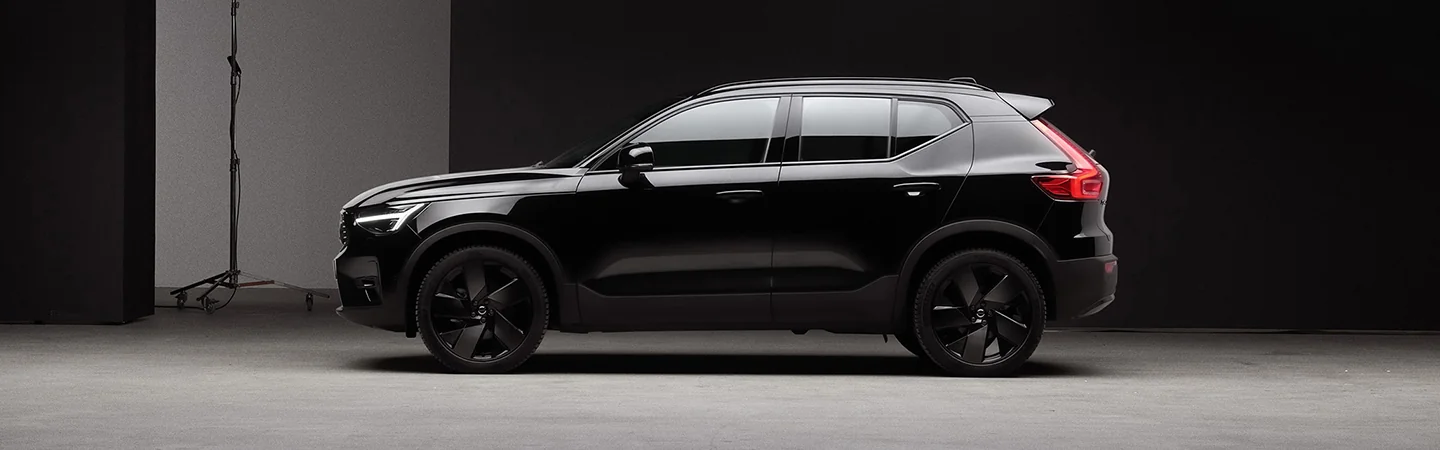 Side view of a 2026 Volvo XC40 parked in a darkly lit parking garage