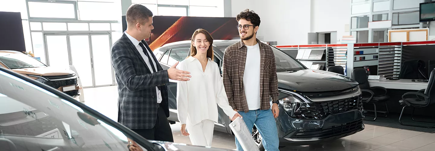 salesman walking with a couple inside the dealership