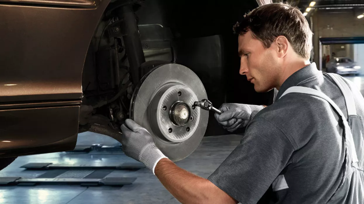 Service mechanic working on a car