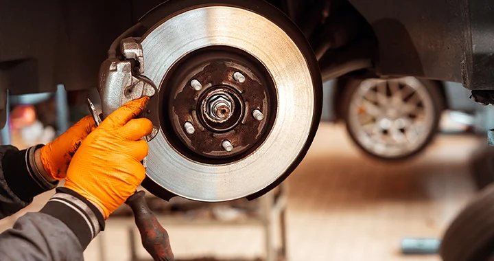 A subaru service tech replacing the brakes on a car in Nederland, TX