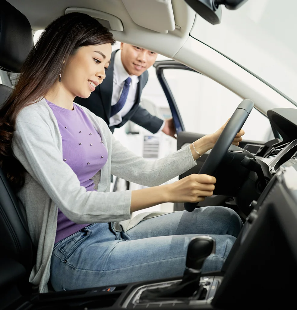 Customer looking at the inside of a new car with a sales person help
