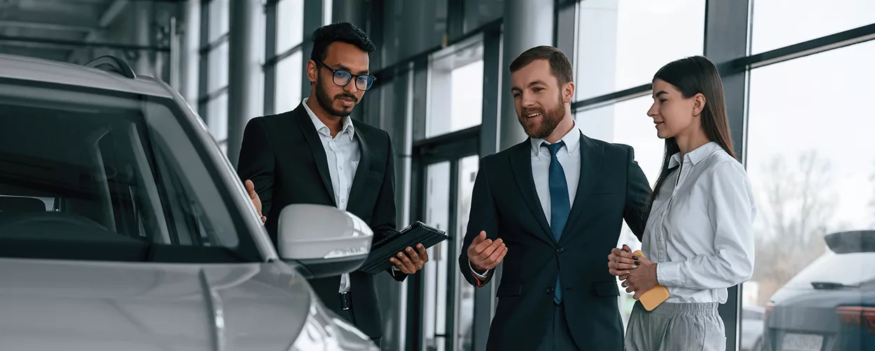 Car salesman showing a customer a new vehcile at a car dealership