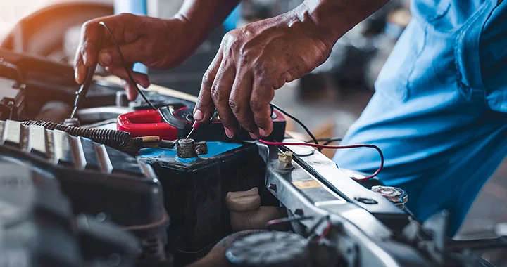 battery being tested by auto mechanic working at Douglass Subaru in Waco, TX