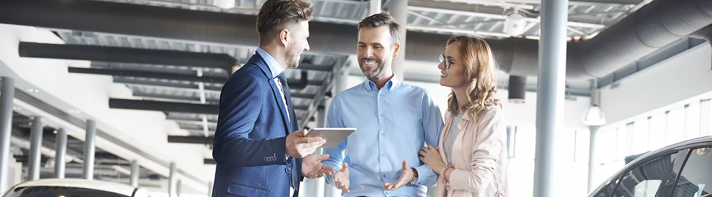 A car salesman talking with a couple