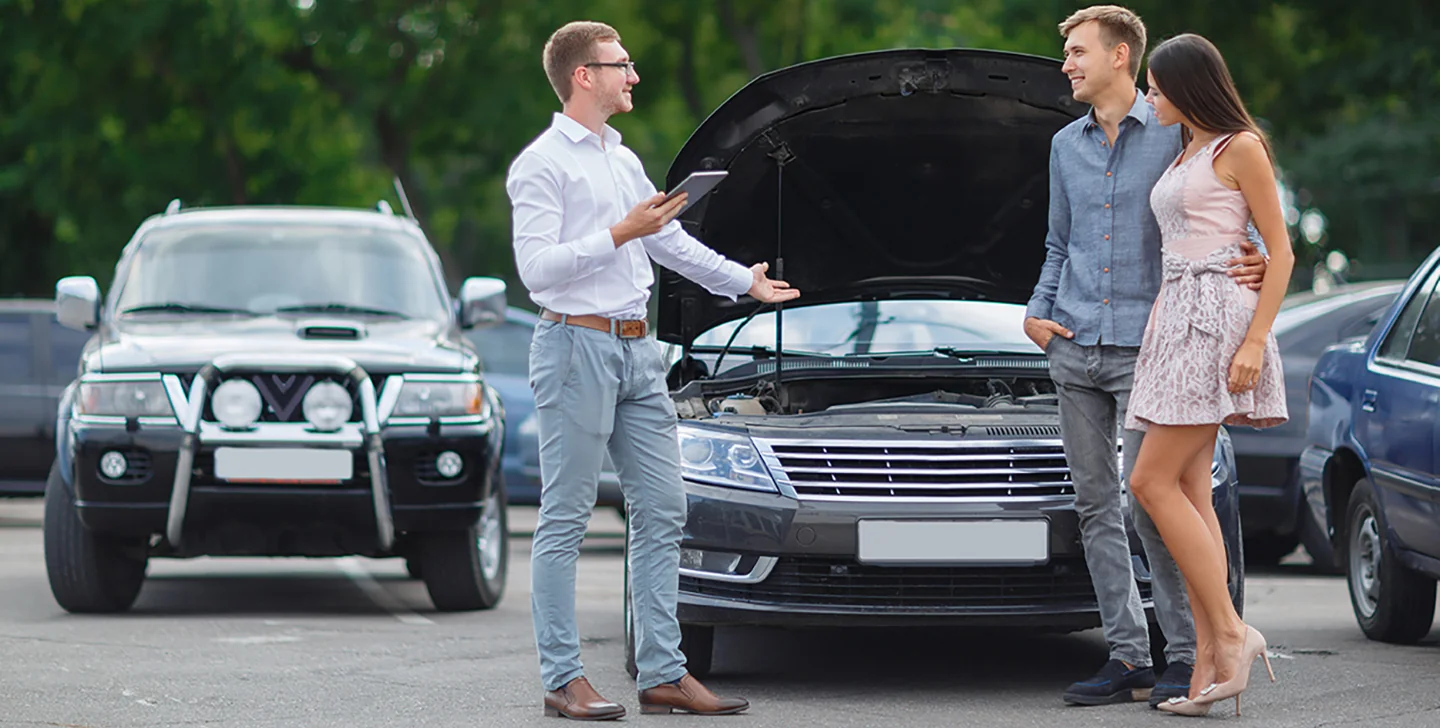 couple speaking with car salesperson on the lot