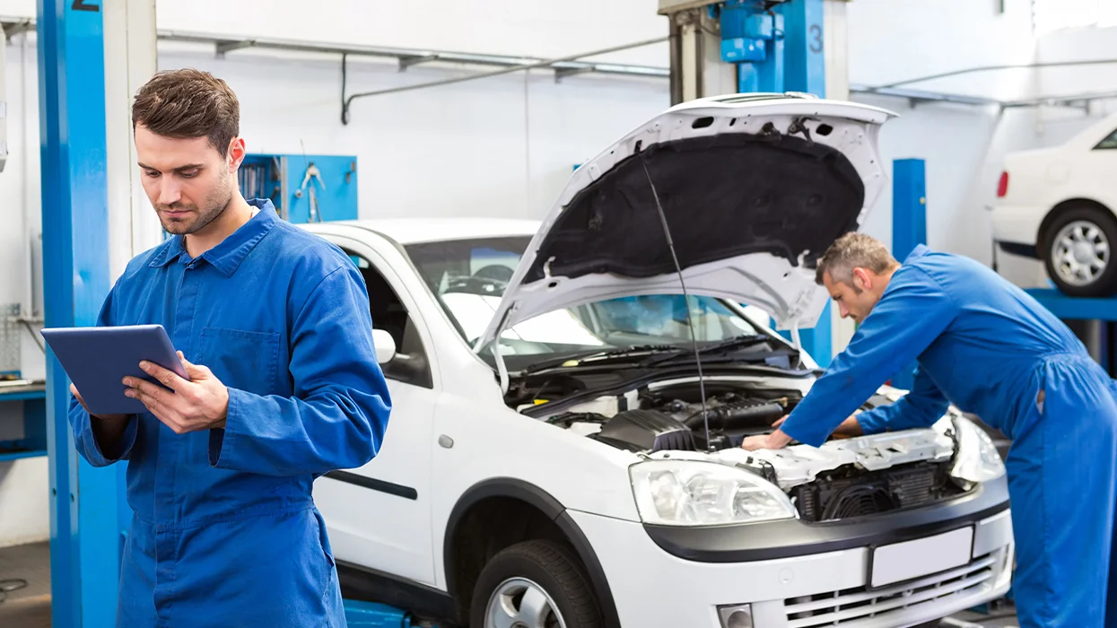 auto mechanics working on cars in service bay