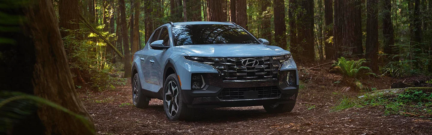 sky blue 2025 Hyundai Santa Cruz driving in forest