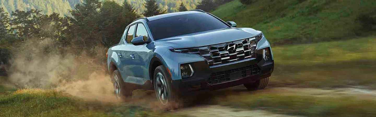 sky blue 2025 Hyundai Santa Cruz parked on lake