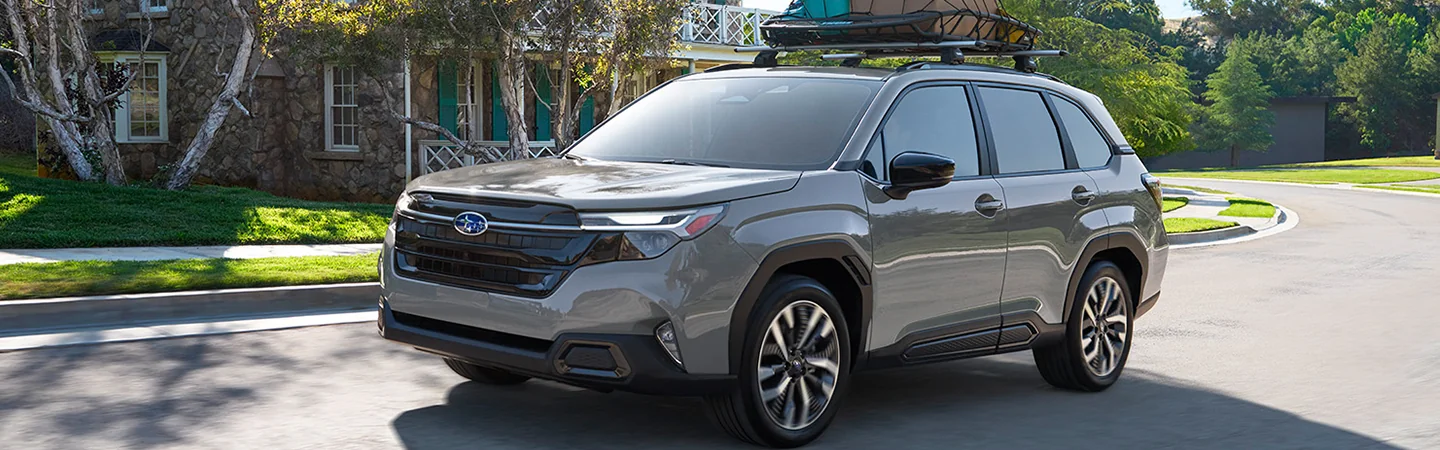 2025 Subaru Forester driving on a neighborhood street with a roof rack in Waco, TX