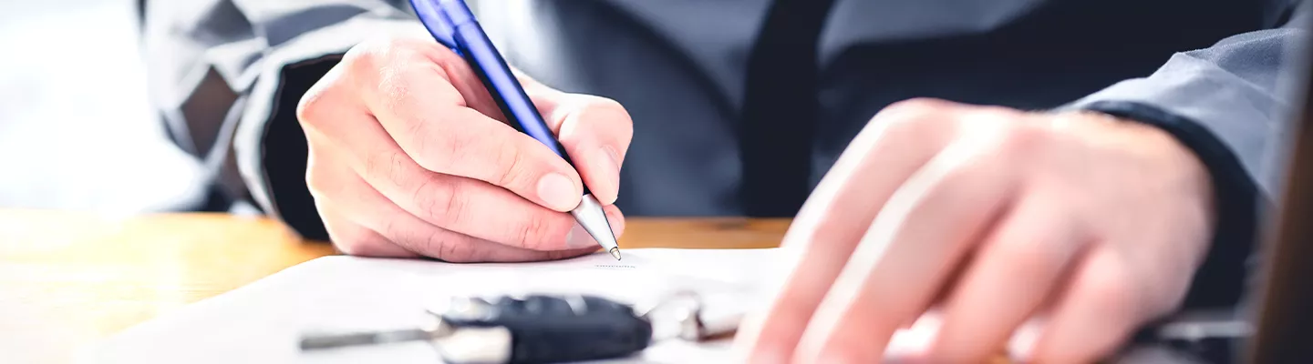 Close up of a person signing a document