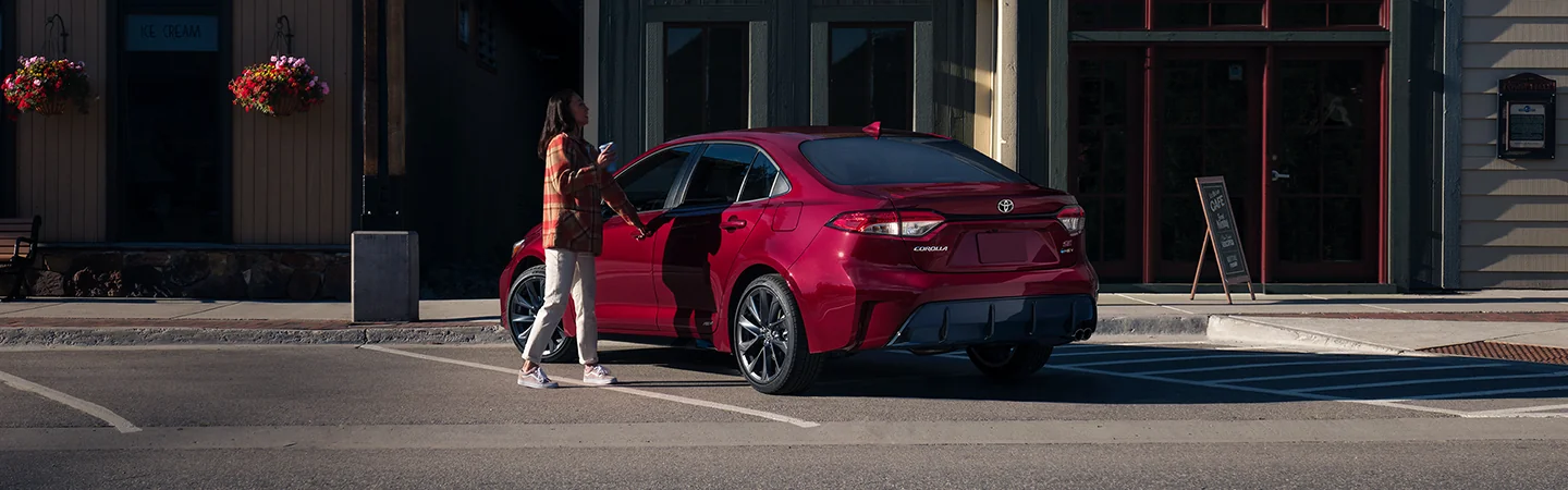 A parked red 2026 Toyota Corolla in front of a store